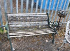 A GARDEN BENCH WITH CAST IRON ENDS and slatted seat and back width 128cm along with a two tiered