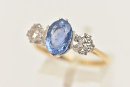 A YELLOW AND WHITE METAL SAPPHIRE AND DIAMOND RING, centring on an oval cut blue sapphire, measuring
