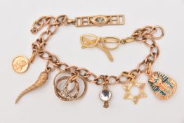 A YELLOW METAL CHARM BRACELET, curb link bracelet links stamped 9.375, fitted with eight charms to