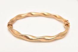 A 9CT GOLD TWIST HINGED BANGLE, hollow bangle, hallmarked 9ct Sheffield, fitted with a figure of