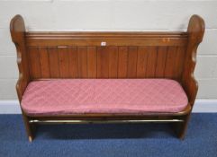 A 20TH CENTURY PINE PEW, with a tubular metal rest, width 130cm x depth 51cm x height 99cm,