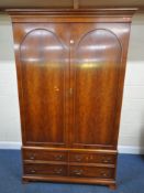 BRADLEY, A YEW WOOD WARDROBE, with double doors, over four drawers, width 129cm x depth 60cm x