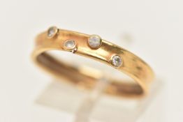 A YELLOW METAL GEM SET BAND RING, concave band set with four collet set colourless stones assessed