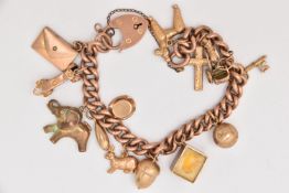 A 9CT GOLD CHARM BRACELET, a yellow gold curb link bracelet fitted with a heart padlock clasp,