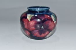 A SMALL MOORCROFT POTTERY 'PANSY' VASE of bulbous from with a tube lined pansy pattern on a blue