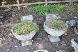 A PAIR OF CARVED RECONSTITUTED STONE GARDEN URNS, with coats of arms and Fleur de Lys detail to 60cm