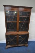 A 20TH CENTURY MAHOGANY BOOKCASE, fitted with a pair of double glazed doors, on ogee bracket feet,