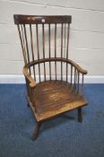A 19TH CENTURY ELM COMB BACK CHAIR, with a curved top rail, spindle supports, scrolled armrests,