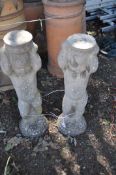 TWO CONCRETE CHERUB FIGURES, one male one female both holding a basket aloft (possibly for bird bath