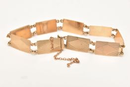 A YELLOW METAL BRACELET, comprised of eight panels and push pin box clasp, engine turned pattern