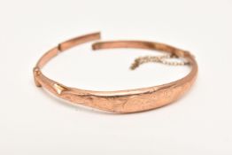 A 9CT ROSE GOLD BANGLE, AF requires attention, decorated with a foliate pattern, push piece