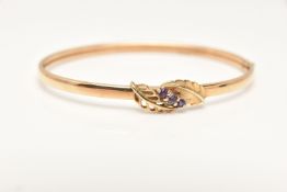 A 9CT GOLD BANGLE, yellow gold hollow bangle with a foliage design to the top of the bangle set with