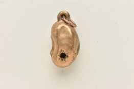 A YELLOW METAL LUCKY BEAN CHARM, star setting with stone missing, approximate length 17mm, stamped