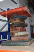 A DECORATIVE SIDE TABLE, in the form of an offset stack of books, rustic wood style in red, blue and