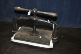 A CAST IRON BOOK PRESS, with a screw handle, 52cm x 25cm, condition report: screw handle loose,
