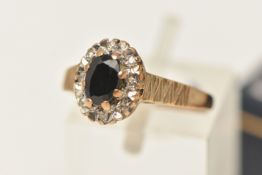 A 9CT GOLD GEM SET RING, a principally set oval cut blue sapphire, prong set with a surround of