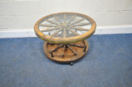 A TWO TIER CIRCULAR TABLE IN THE FORM OF A CARRIAGE WHEEL, with brass banding, raised on castors,