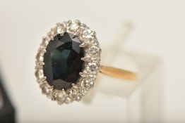 A GEM SET CLUSTER RING, a large oval cut green stone assessed a synthetic spinel, prong set in white