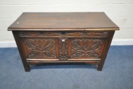 A GEORGIAN OAK COFFER, with a hinged lid, the front with geometric and foliate patterns, width 130cm