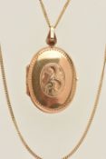 A 9CT GOLD LOCKET, yellow gold oval form locket with scrolling acanthus detail to the front,