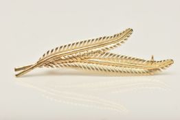 A YELLOW METAL BROOCH, a foliage design brooch, approximate length 59mm, stamped 9ct, approximate