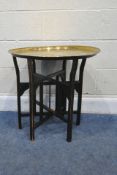 A 20TH CENTURY BRASS TRAY TOP TABLE, with repeating patterns, on a folding support, diameter 59cm