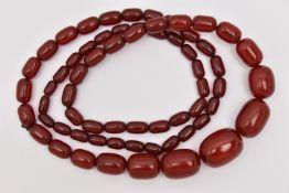 A BAKELITE NECKLACE, a cherry amber Bakelite beaded necklace, oval graduating beads, largest bead