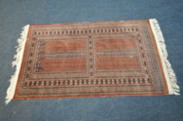 A RED GROUND RECTANGULAR WOOLLEN RUG, with repeating geometric patterns, surrounded by a multi-strap