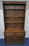 AN ERCOL ELM AND BEECH WALL CABINET, with three shelves, atop a base with two drawers over double