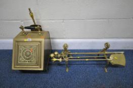 A BRASS COAL SCUTTLE, with a single handle and door, raised on turned legs, carrying a small shovel,