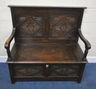 AN EARLY 20TH CENTURY OAK SETTLE, with open armrests, four panels with geometric designs, and a
