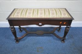 AN EDWARDIAN MAHOGANY DUET PIANO STOOL, with an upholstered lid, raised on turned legs, united by
