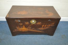 A 20TH CENTURY CAMPHORWOOD CHEST, with carved details, depicting trees and buildings, a handle to