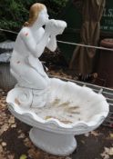 A MODERN PAINTED CONCRETE GARDEN WATER FEATURE in the form of a mermaid knelt on a shell, depth