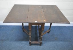 AN EARLY 20TH CENTURY OAK GATE LEG TABLE, raised on turned legs, united by stretchers, open width