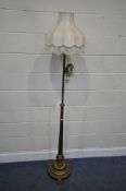 A BRASS TELESCOPIC STANDARD LAMP, raised on a tapered support, on a shaped base, with three feet,