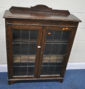 A 20TH CENTURY OAK BOOKCASE, with a raised back, and double lead glazed doors, width 90cm x depth