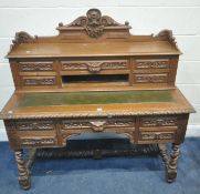 A LATE VICTORIAN CARVED OAK DESK, comes in two sections, an arrangement of ten drawers with green