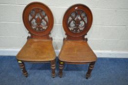 A PAIR OF VICTORIAN MAHOGANY HALL CHAIRS, with pierced backrests, raised on turned front legs,
