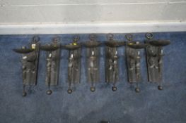 A SET OF SEVEN IRON MEDIEVAL STYLE WALL SCONCES, with rings to the top, dished fittings, and