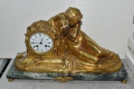 A FRENCH GILT BRONZE FIGURAL MANTEL CLOCK, depicting a female figure in classical dress seated on