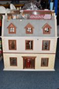 A VINTAGE THREE STOREY DOLLS HOUSE, featuring a brick style base with front opening hinged door