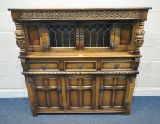 AN OLD CHARM OAK COURT CUPBOARD, with double lead glazed doors, flanked by bulbous supports, above
