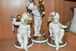 THREE GIUSEPPE CALLÉ CAPODIMONTE FIGURES OF CHERUBS, the porcelain figures wearing gilt and silver
