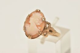 A YELLOW METAL CAMEO RING, an oval shell cameo, prong set in yellow metal, bow detail to the