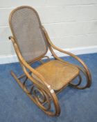 AFTER MICHAEL THONET, A BENTWOOD ROCKING ARMCHAIR, with cane seat and backrest, width 53cm x depth