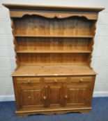A MODERN PINE DRESSER, the three tier plate rack atop a base, fitted with three drawers, over two