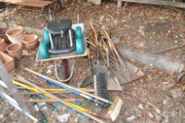 A WHEELBARROW AND A QUANTITY OF GARDEN TOOLS, including Kenyon shovels, spades, forks, rakes, how's,