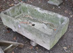 A STONE RECTANGULAR GARDEN TROUGH, with a drainage hole to the centre, raised on twin supports,