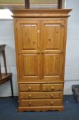 A MODERN PINE DOUBLE DOOR WARDROBE, width 107cm x depth 62cm x height 105cm, atop a base with two
